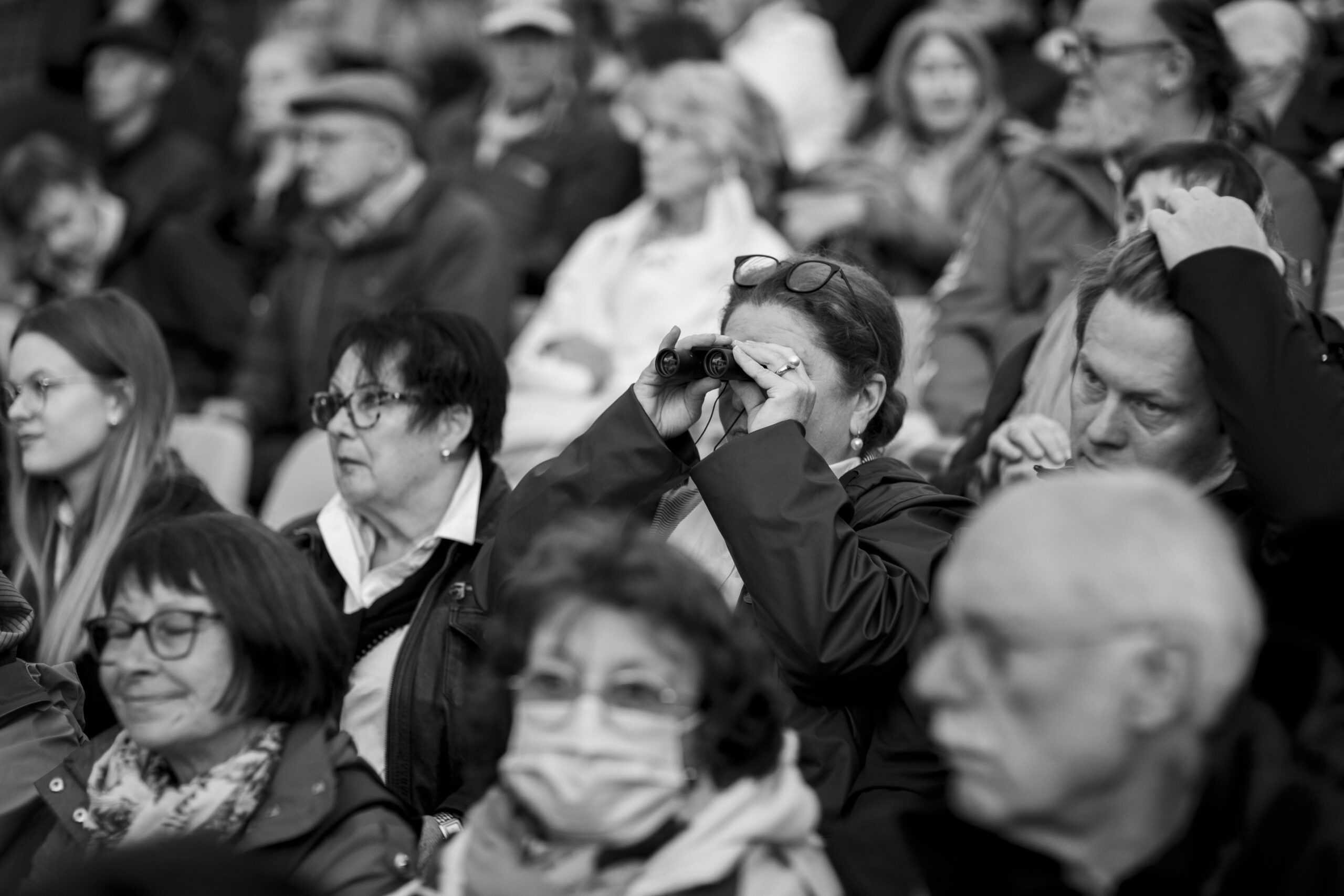 mujer con prismáticos entre la gente